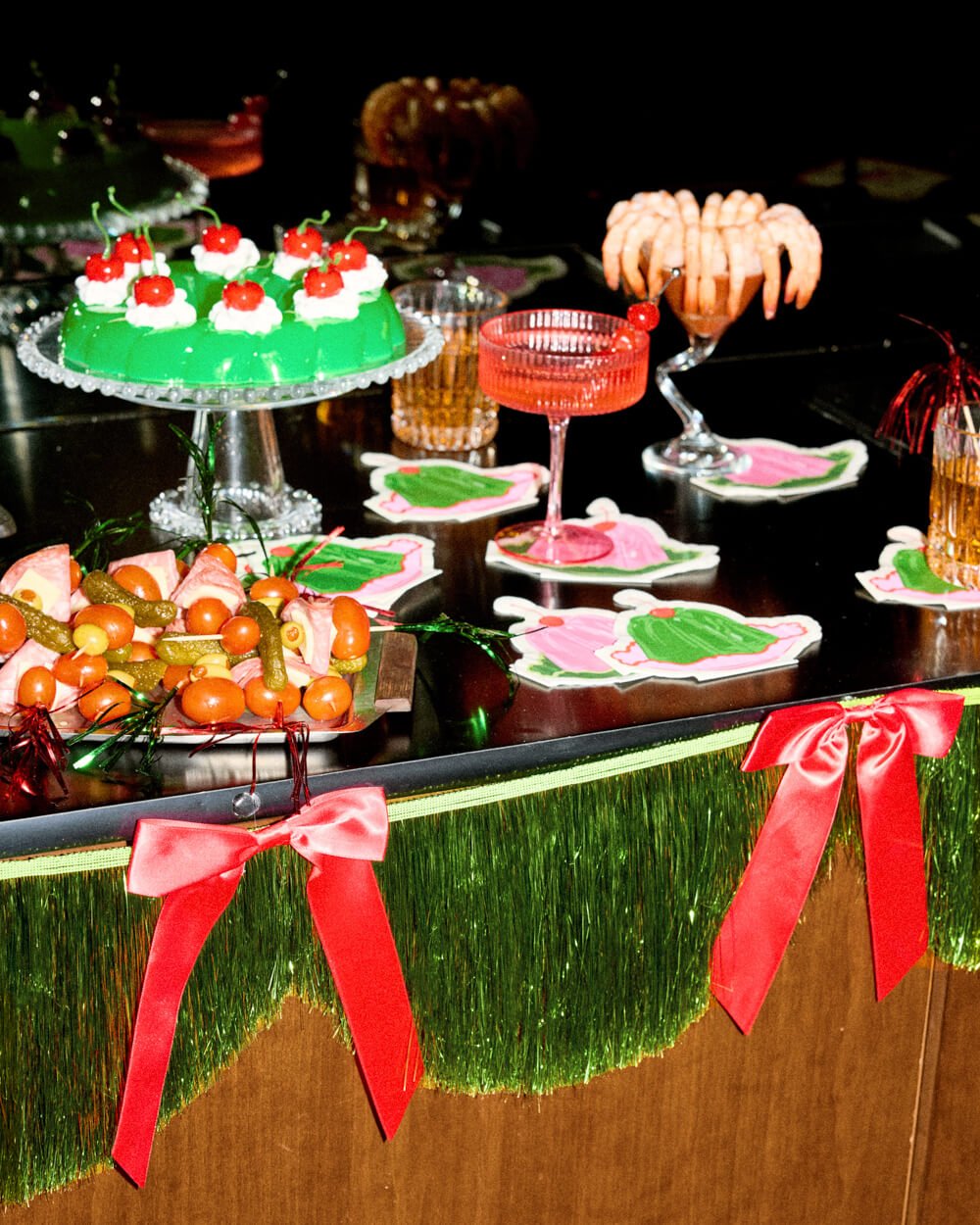 Green fringe banner pinned along a bar front beside cakes and cocktails