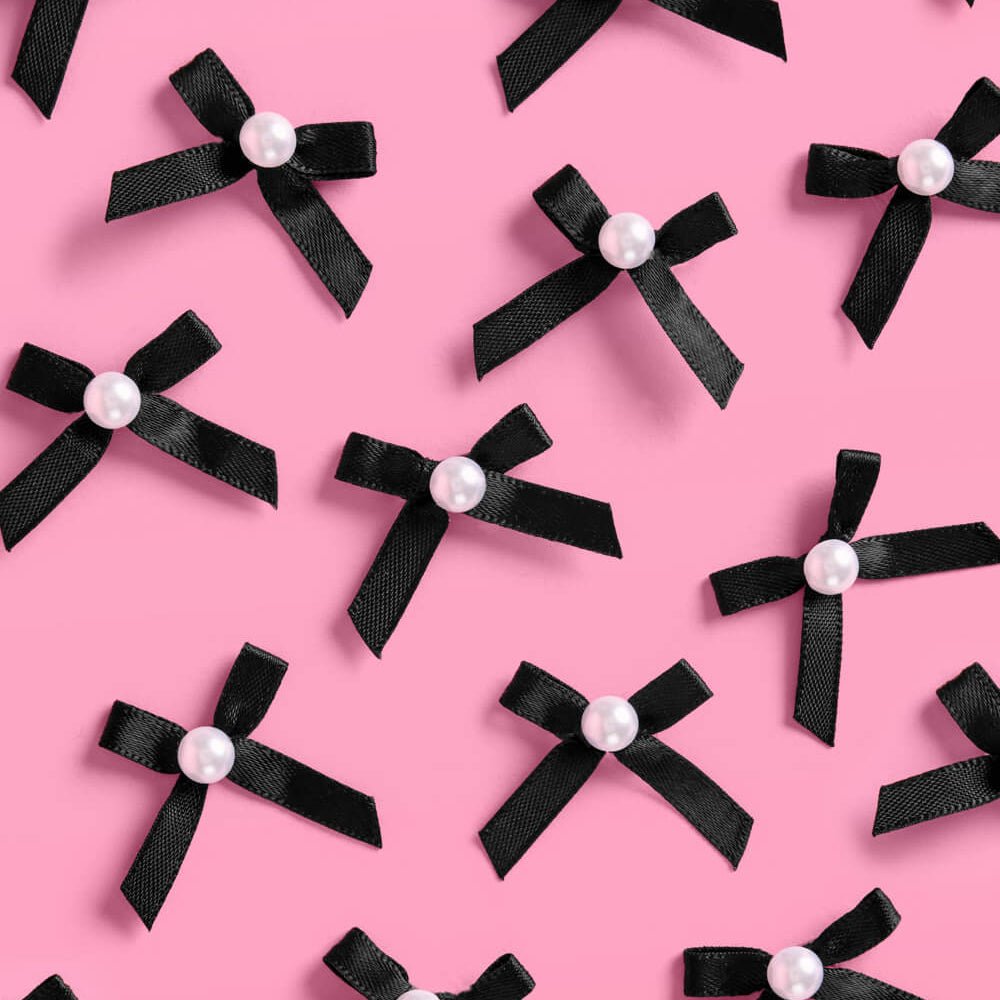Black and pearl bow cake toppers styled on cupcakes for a birthday or bachelorette party
