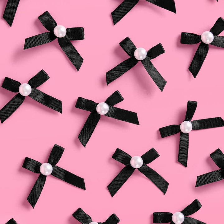 Black and pearl bow cake toppers styled on cupcakes for a birthday or bachelorette party