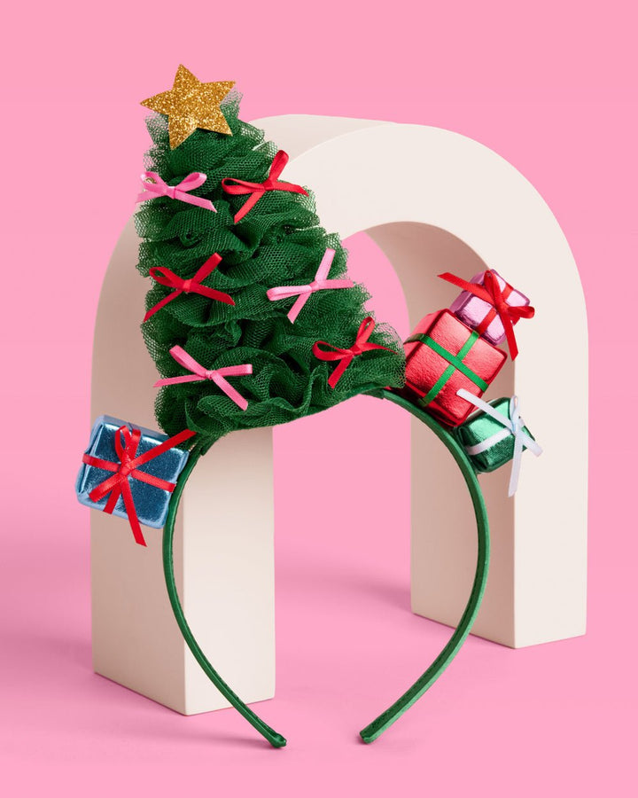 Christmas tree headband on a cream arch, showing the tulle tree and wrapped presents on the band