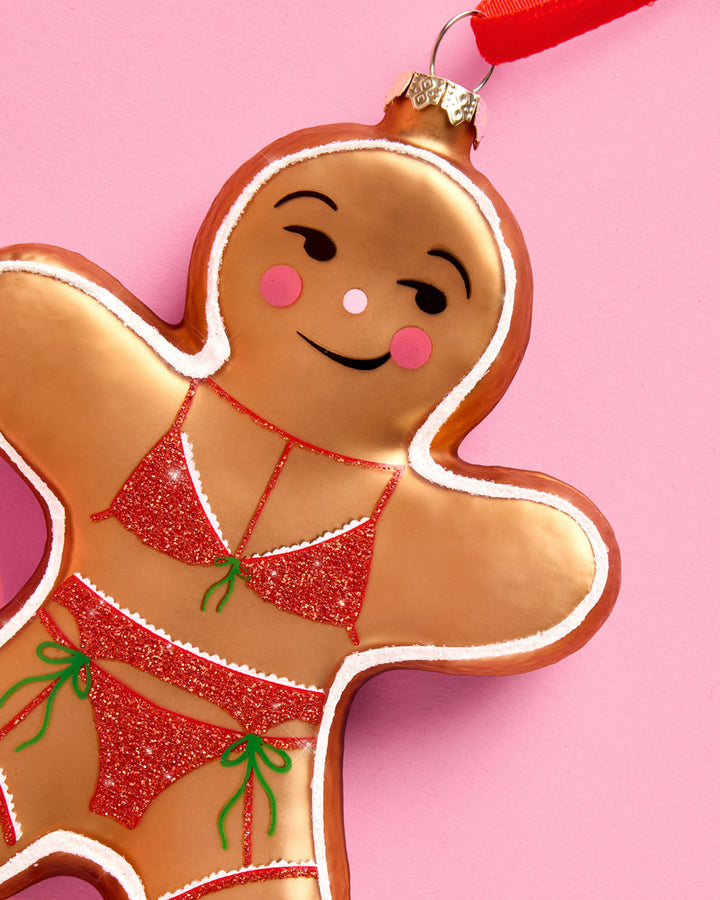 Additional product view of the naughty gingerbread girl glass Christmas ornament.
