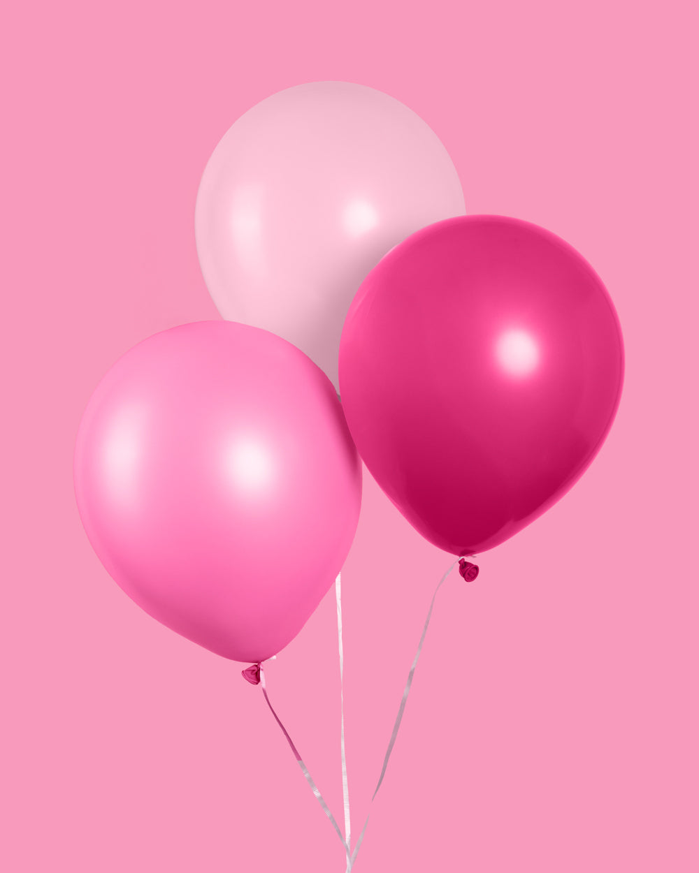 Pink balloons styled as a party backdrop
