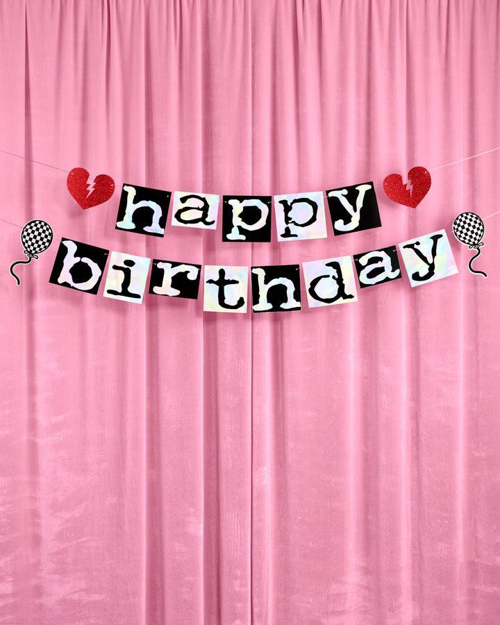 Emo happy birthday banner with red broken hearts and checkered balloons hung against pink curtains