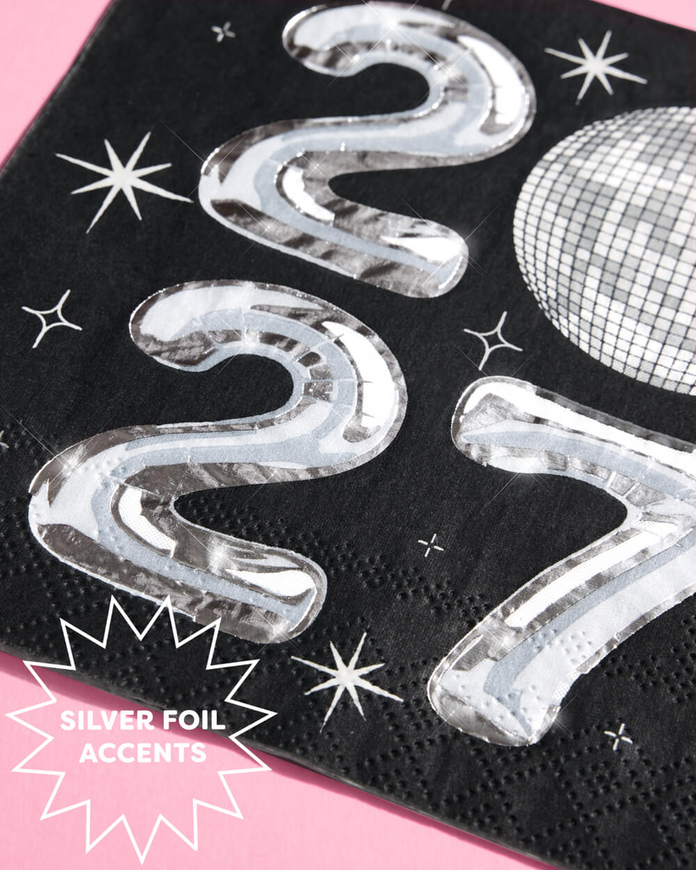 Close view of the silver foil 2027 numerals and starburst accents on the napkin