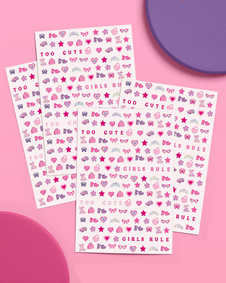 Four sheets of pink party nail art stickers fanned out on a pink and purple background