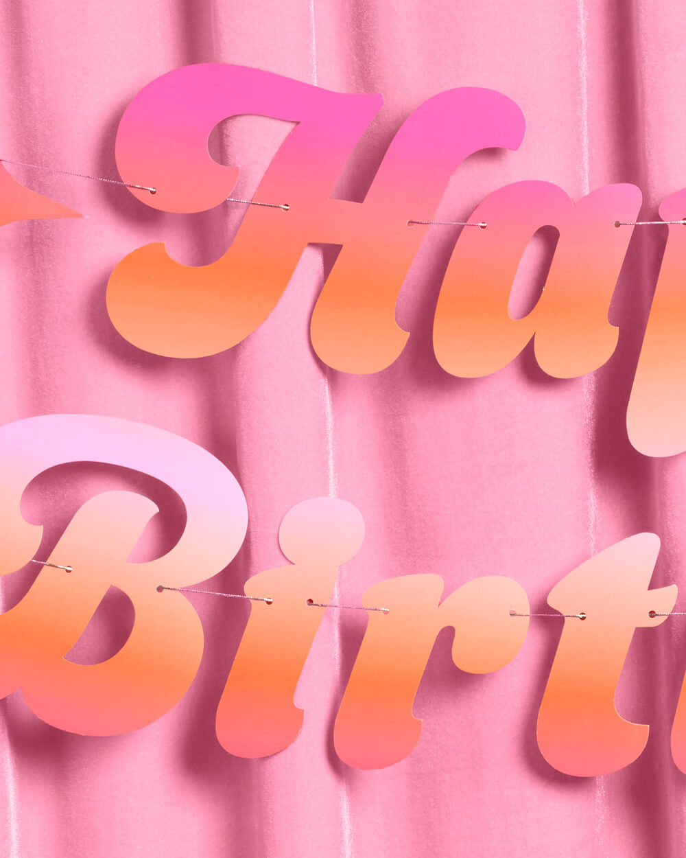 Close-up of the pink and orange ombre cursive lettering on the Happy Birthday banner