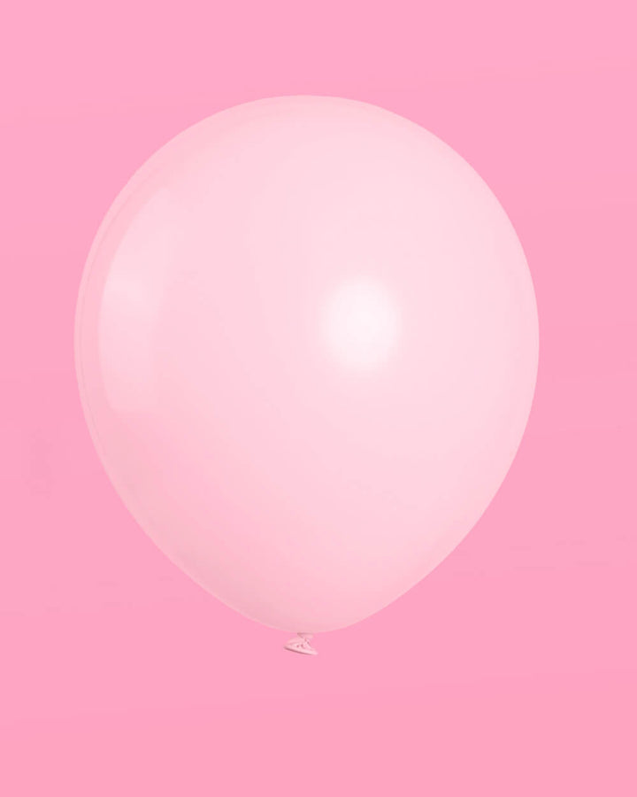 Single macaron pink latex balloon on a pink background