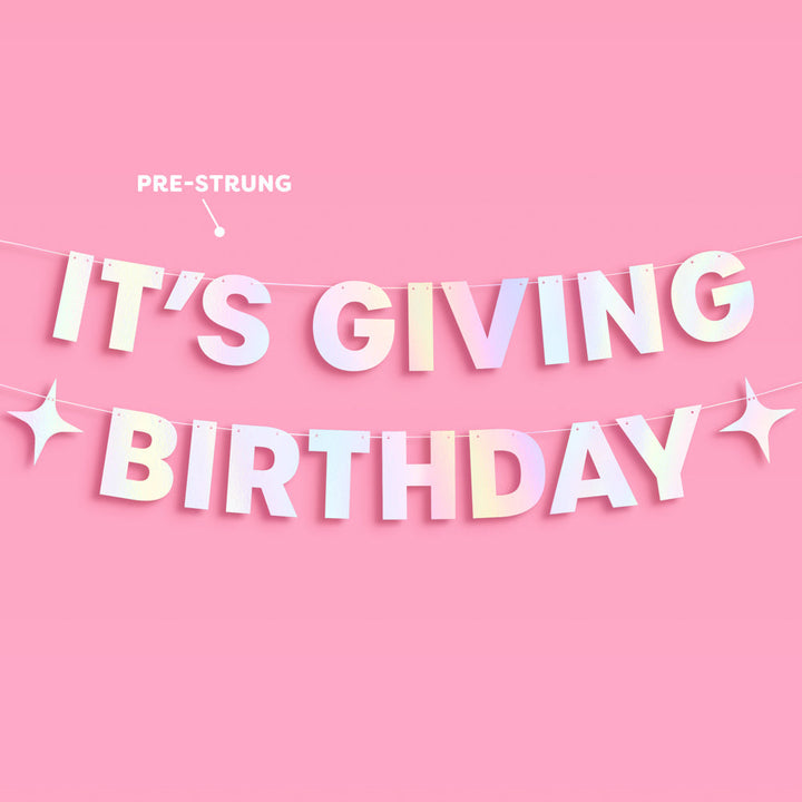 Iridescent foil birthday banner styled on a pink wall