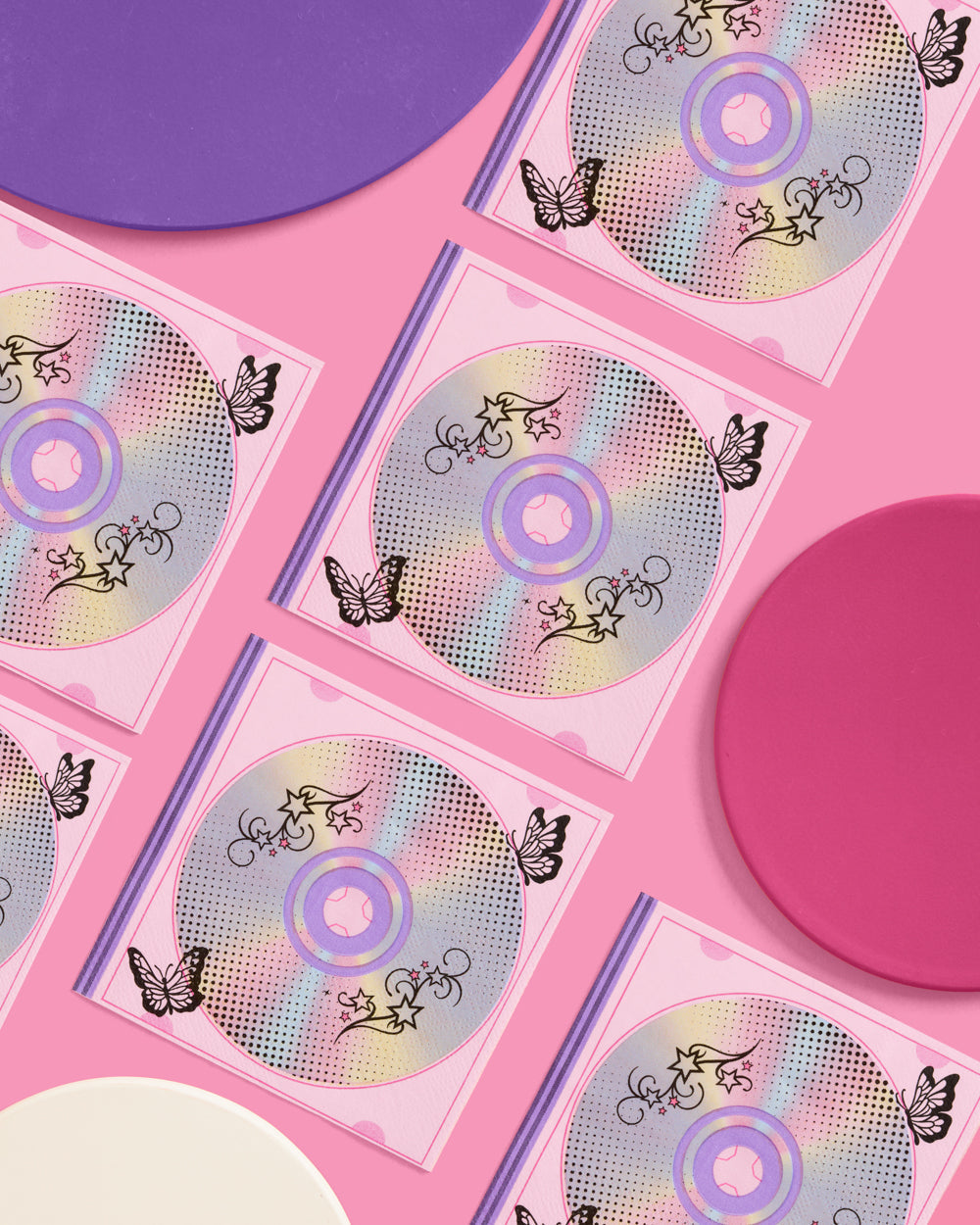 Rows of Y2K iridescent CD print napkins arranged on a pink and purple backdrop