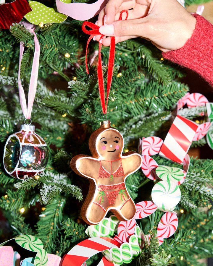 Additional view of the gingerbread girl ornament and its red velvet ribbon with gold hardware.