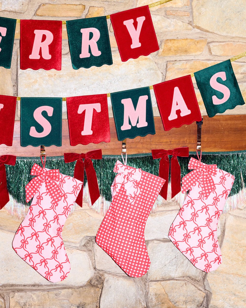 Merry Christmas velvet banner hung across a stone wall