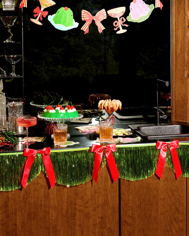 Green fringe banner used as a table skirt on a holiday bar