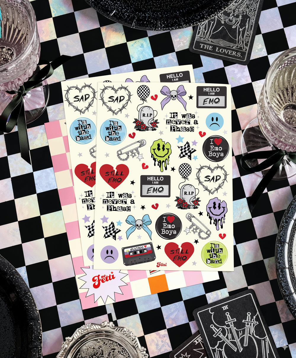 Sheet of emo foil temporary tattoos on a black and white checkered table with silver party plates