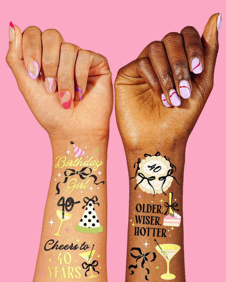 Two arms wearing gold foil 40th birthday temporary tattoos
