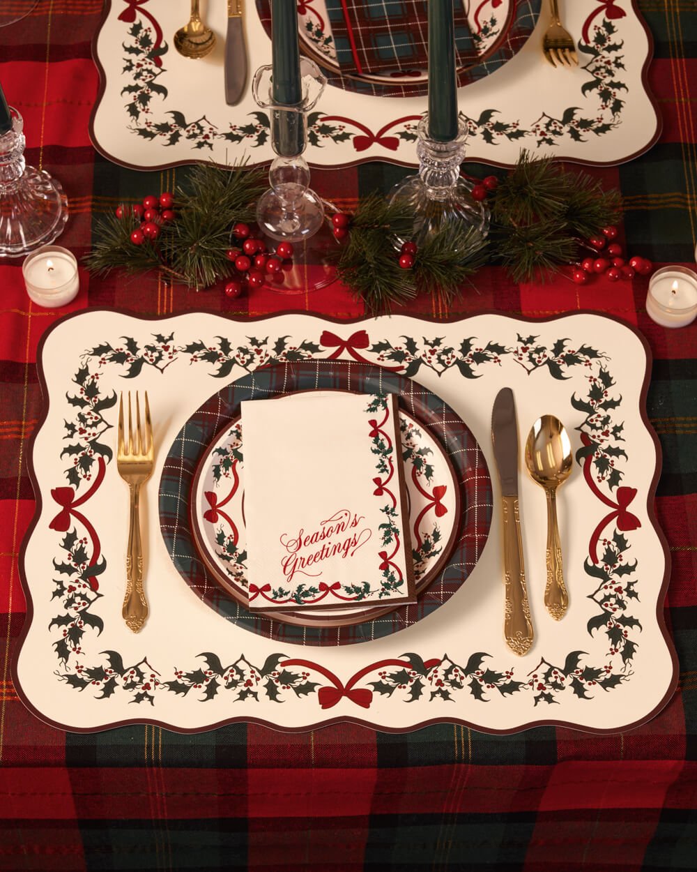 Christmas tree placemat set with a plate, gold cutlery, and green taper candles