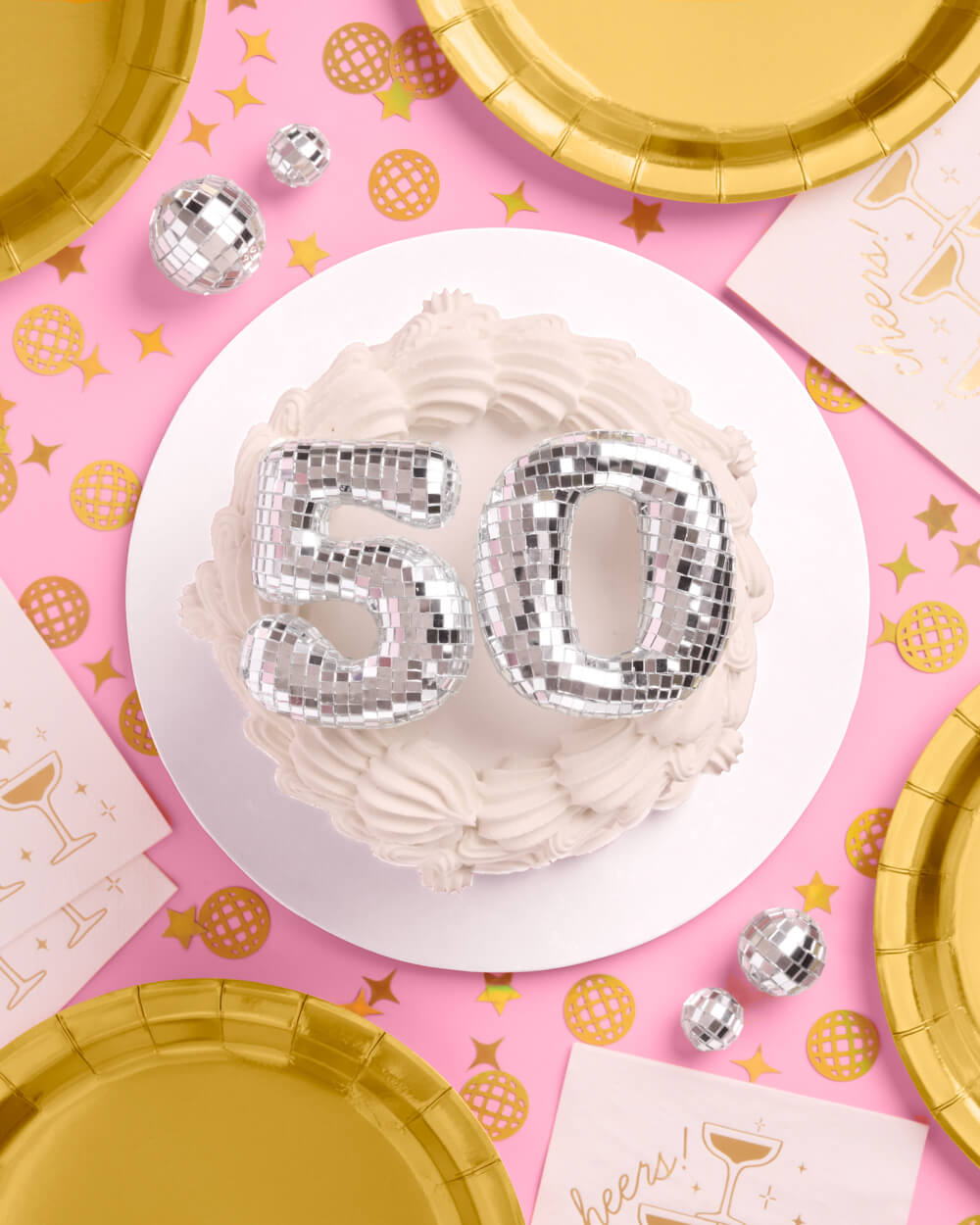 Mirrored 50 disco cake topper styled on a pink surface