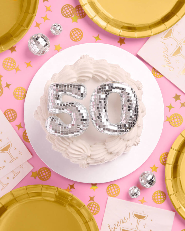 Mirrored 50 disco cake topper styled on a pink surface