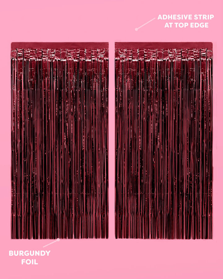 Two burgundy fringe curtain panels showing the adhesive strip along the top edge