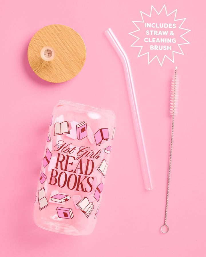 Glass tumbler laid flat with its bamboo lid, curved glass straw, and cleaning brush, the full set on pink