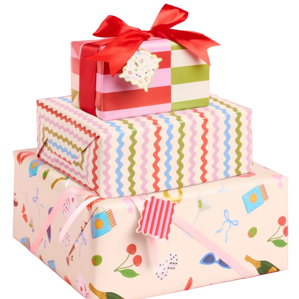 Gifts wrapped in cream paper printed with champagne, martinis, lipstick, and cherries, with rickrack and stripe papers.