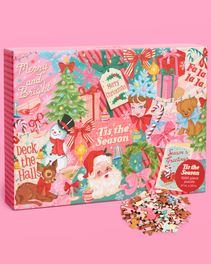 Pinkmas 1000-piece Christmas puzzle box with retro Santa, reindeer, gifts, and trees, beside loose pieces.