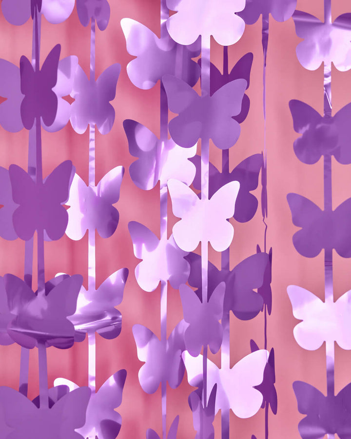 Lilac and deep purple butterfly cutouts turning on the strands of a butterfly curtain