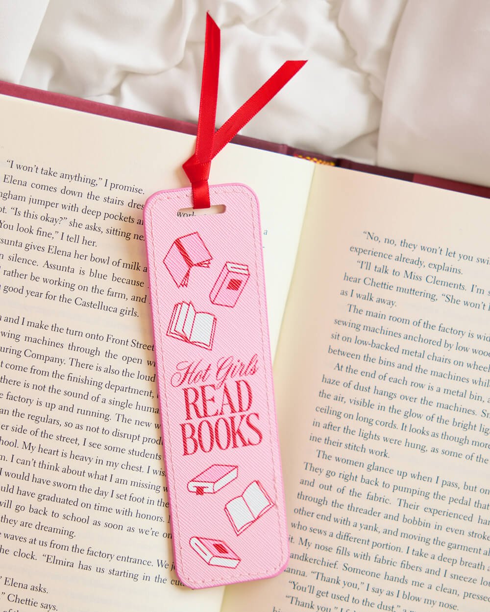 Pink faux leather Hot Girls Read Books bookmark with a red satin ribbon in an open book