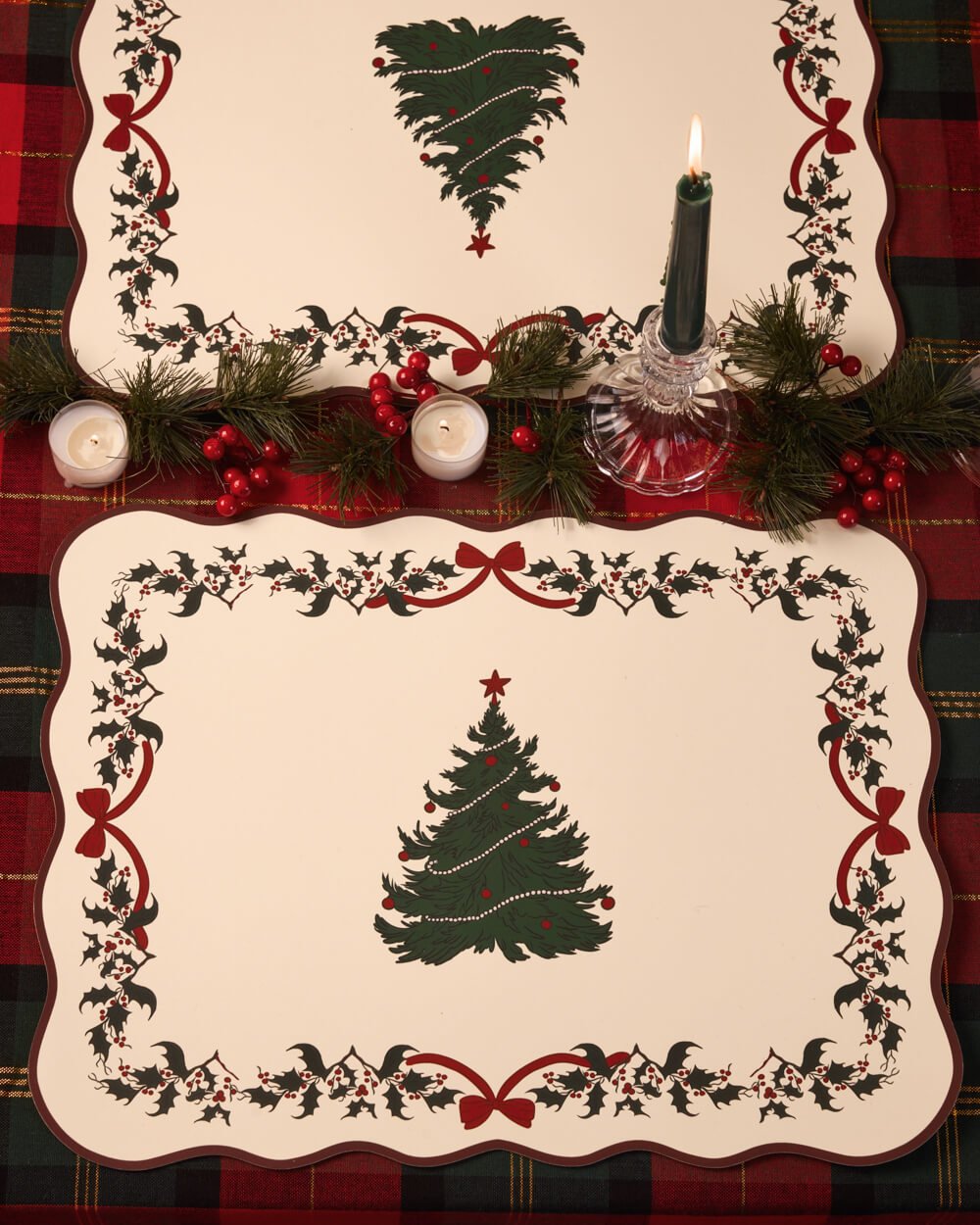 Christmas tree paper placemat styled with a lit taper candle and greenery