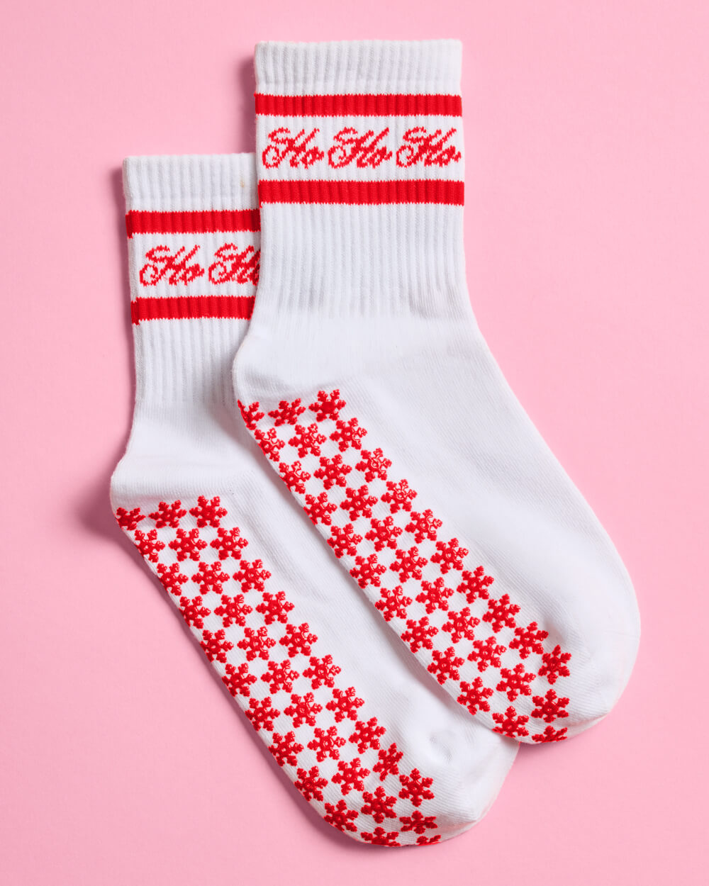 Red and white Ho Ho Ho grip socks with a striped cuff and red snowflake grips on the sole