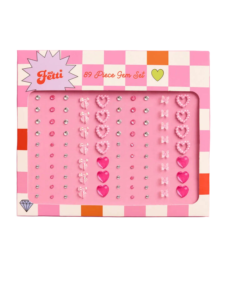 89-piece gem set packaging with pink and white checkered border on a pink background