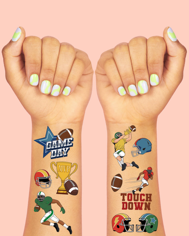 Football temporary tattoos on two wrists showing a Game Day star, helmet, trophy, and touchdown art