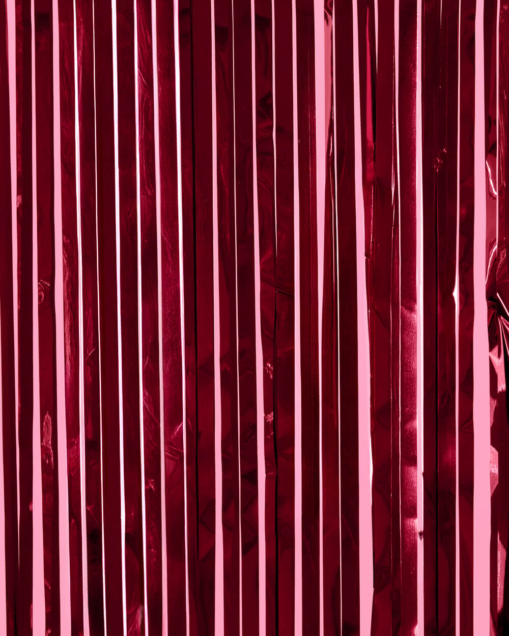 Burgundy metallic foil fringe curtain hung full width as a deep wine party backdrop