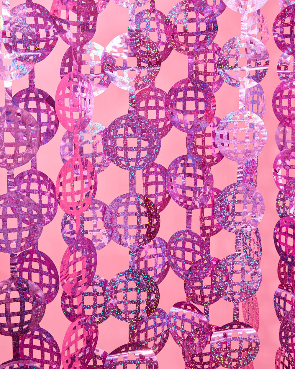 Hot pink laser-cut disco ball foil curtain strands hung as a disco party backdrop