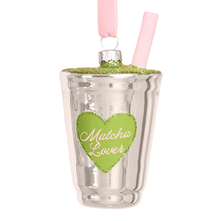 Mirrored silver matcha to-go cup glass ornament topped with green glitter, with a pale pink straw and a green Matcha Lover heart, hanging from a pink velvet ribbon.