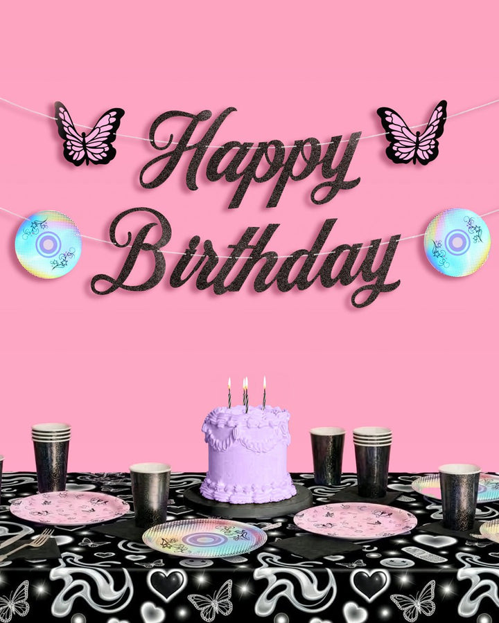 Y2K Happy Birthday banner above a black party table with a purple cake, iridescent plates, and black cups