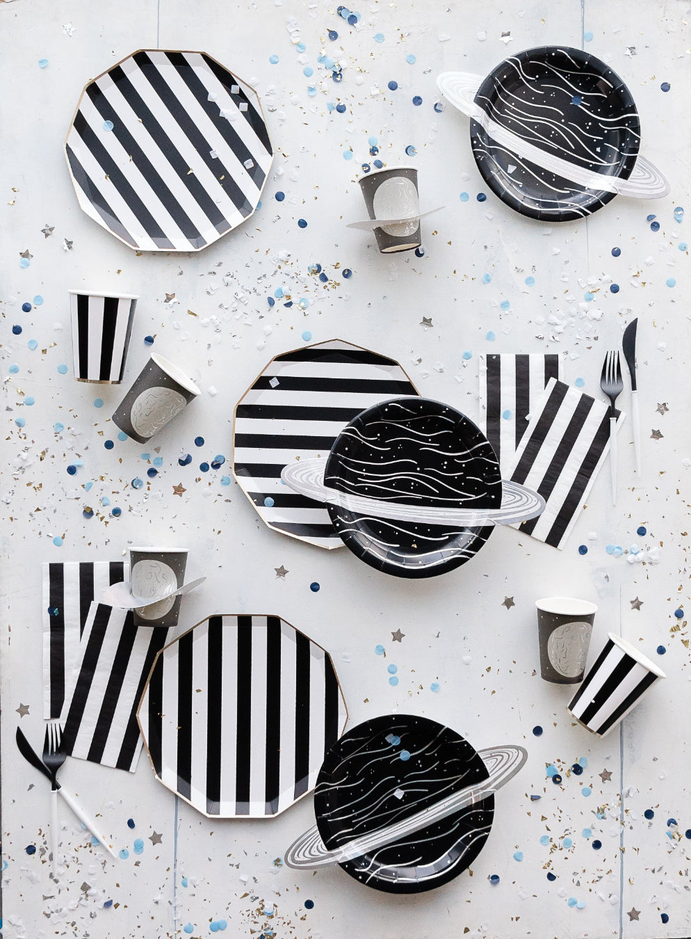 Space themed party supplies styled on a table for a kids space birthday party