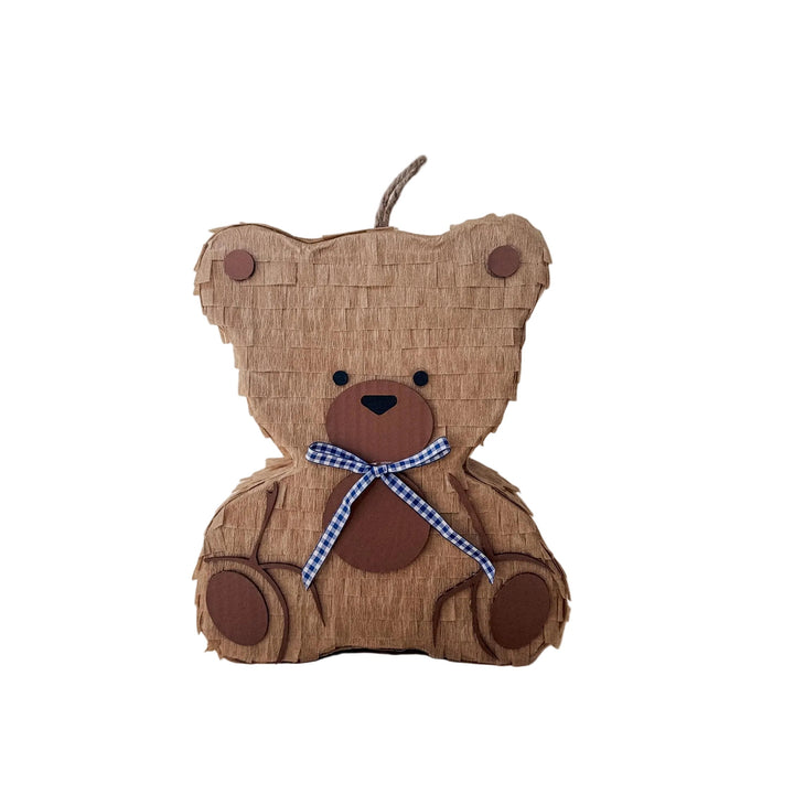 Teddy bear-shaped piñata with a blue ribbon on a beige background