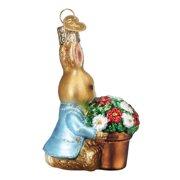 Opposite side of the Peter Rabbit ornament showing his blue jacket and tail behind the flower pot, on white