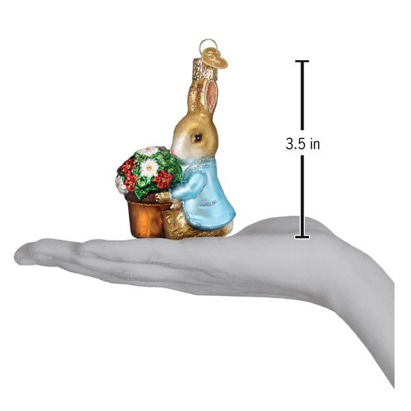 Peter Rabbit flower pot ornament on an open palm beside a 3.5 inch height marker