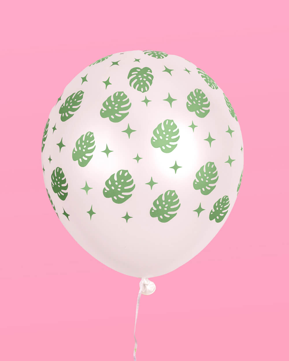 Single light pink latex balloon with a green palm leaf print