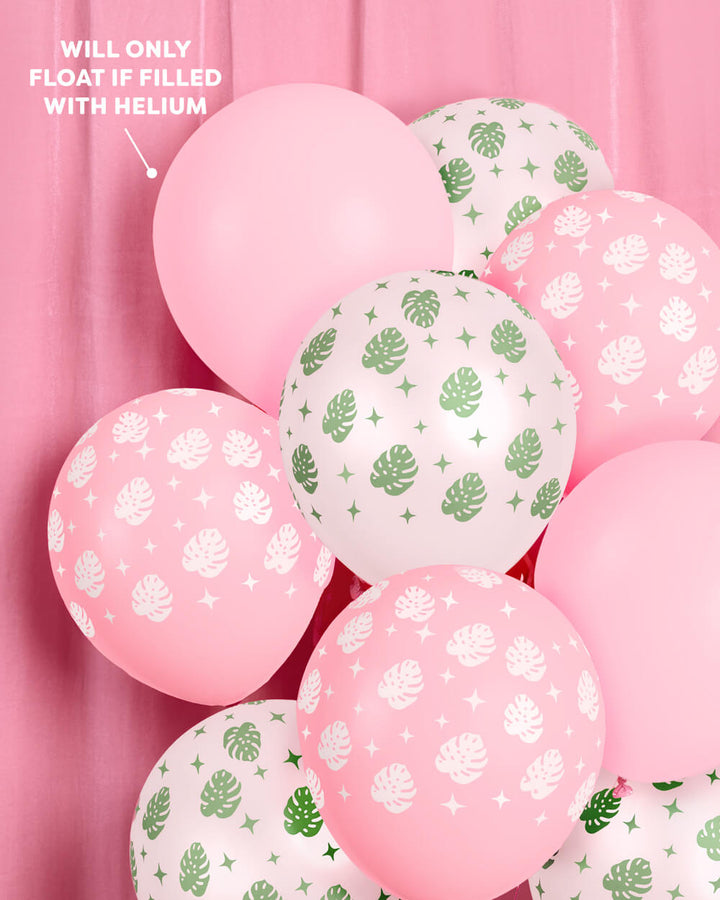 Bunch of tropical palm latex balloons against a pink backdrop