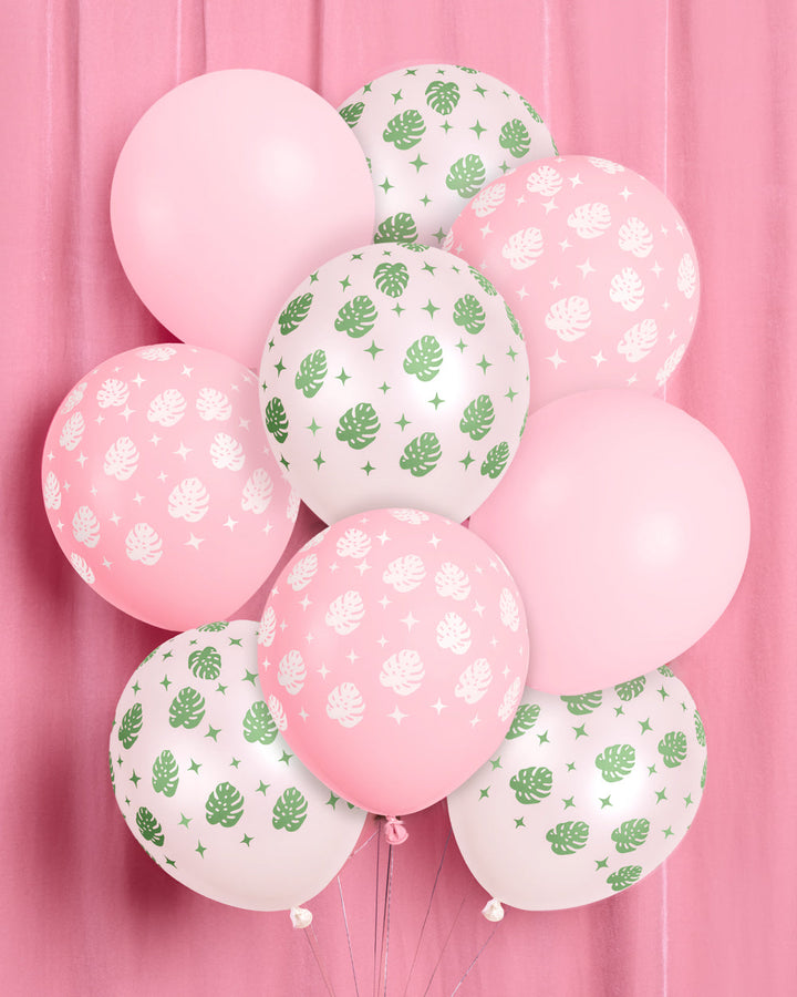 Bunch of tropical palm latex balloons in pink and white with a green palm leaf print