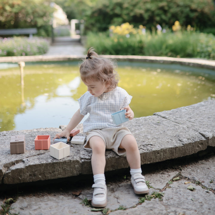 Children playing with the Mushie mix and match silicone toy