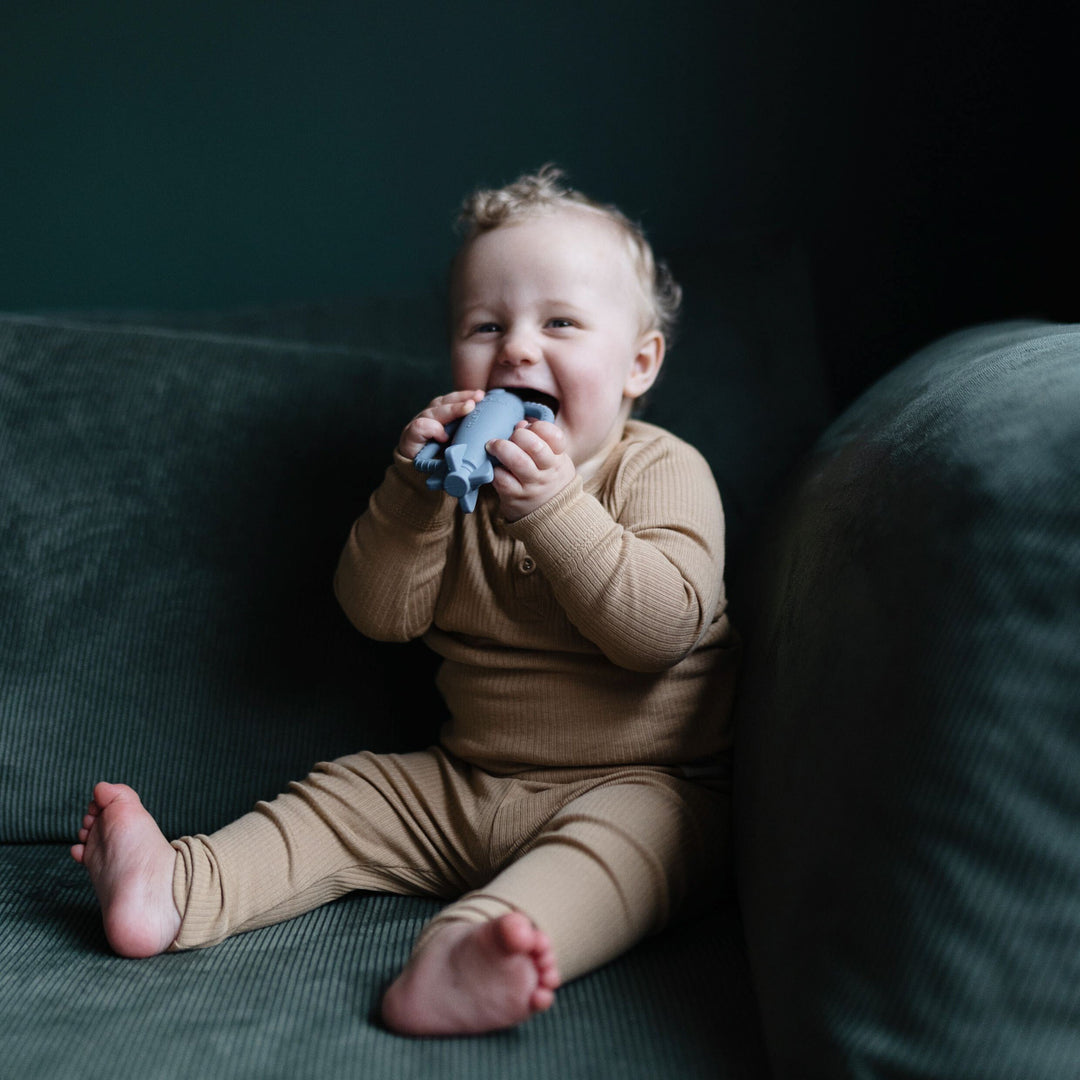 Baby playing with a Mushie silicone rattle teether