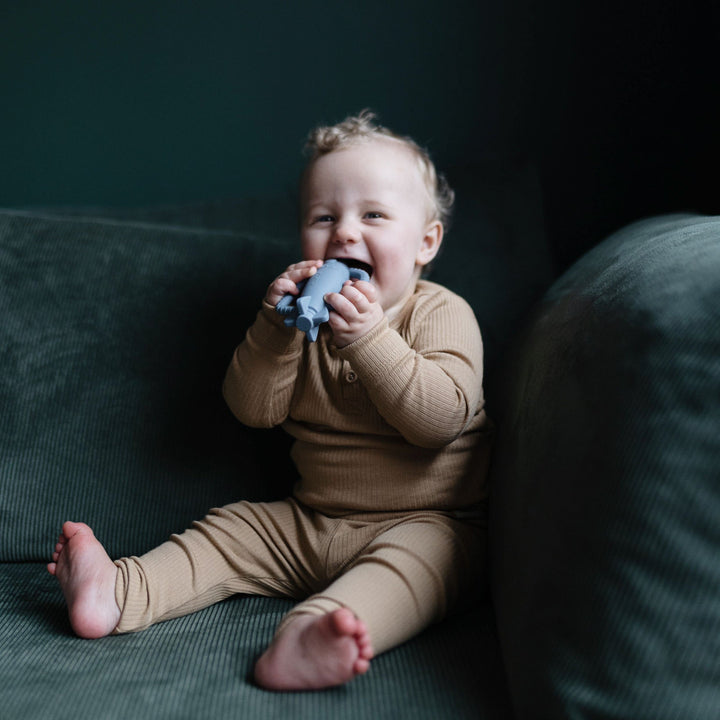 Baby playing with a Mushie silicone rattle teether