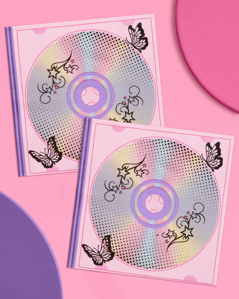 Two Y2K cocktail napkins with holographic CD prints on pink and purple circles