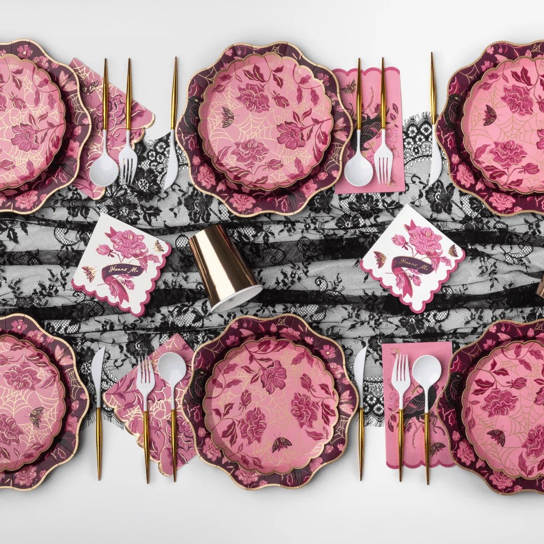 A vamp romantic tablescape with elegant party supplies for a Halloween dinner party.