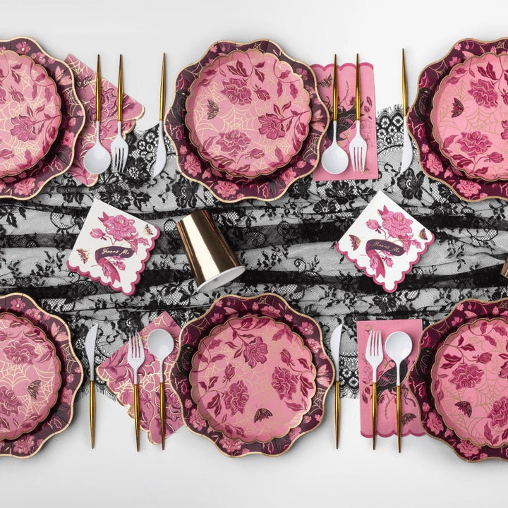 A vamp romantic tablescape with elegant party supplies for a Halloween dinner party.