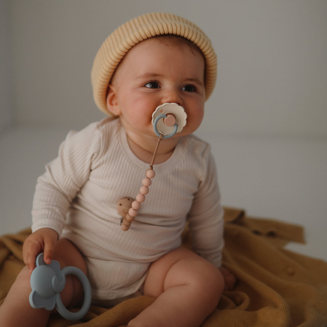 Baby playing with a Mushie animal ring teether