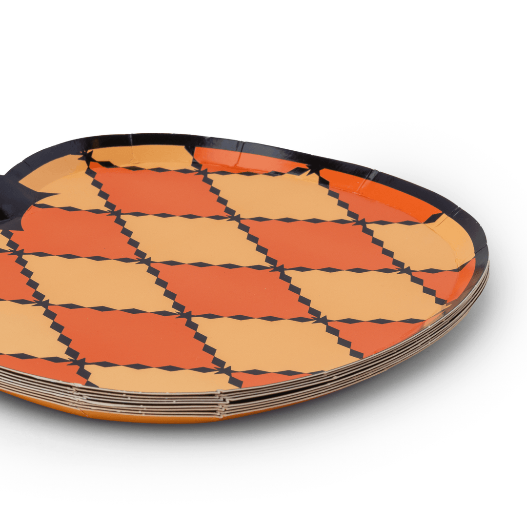 Stack of harlequin pumpkin Halloween plates showing the checkered rim design